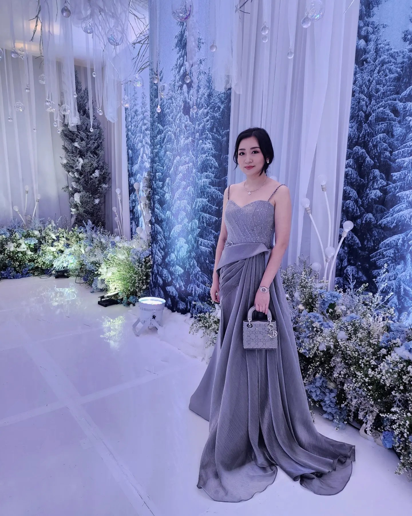 Celine Ratna in a draped silver-grey gown at a wedding reception