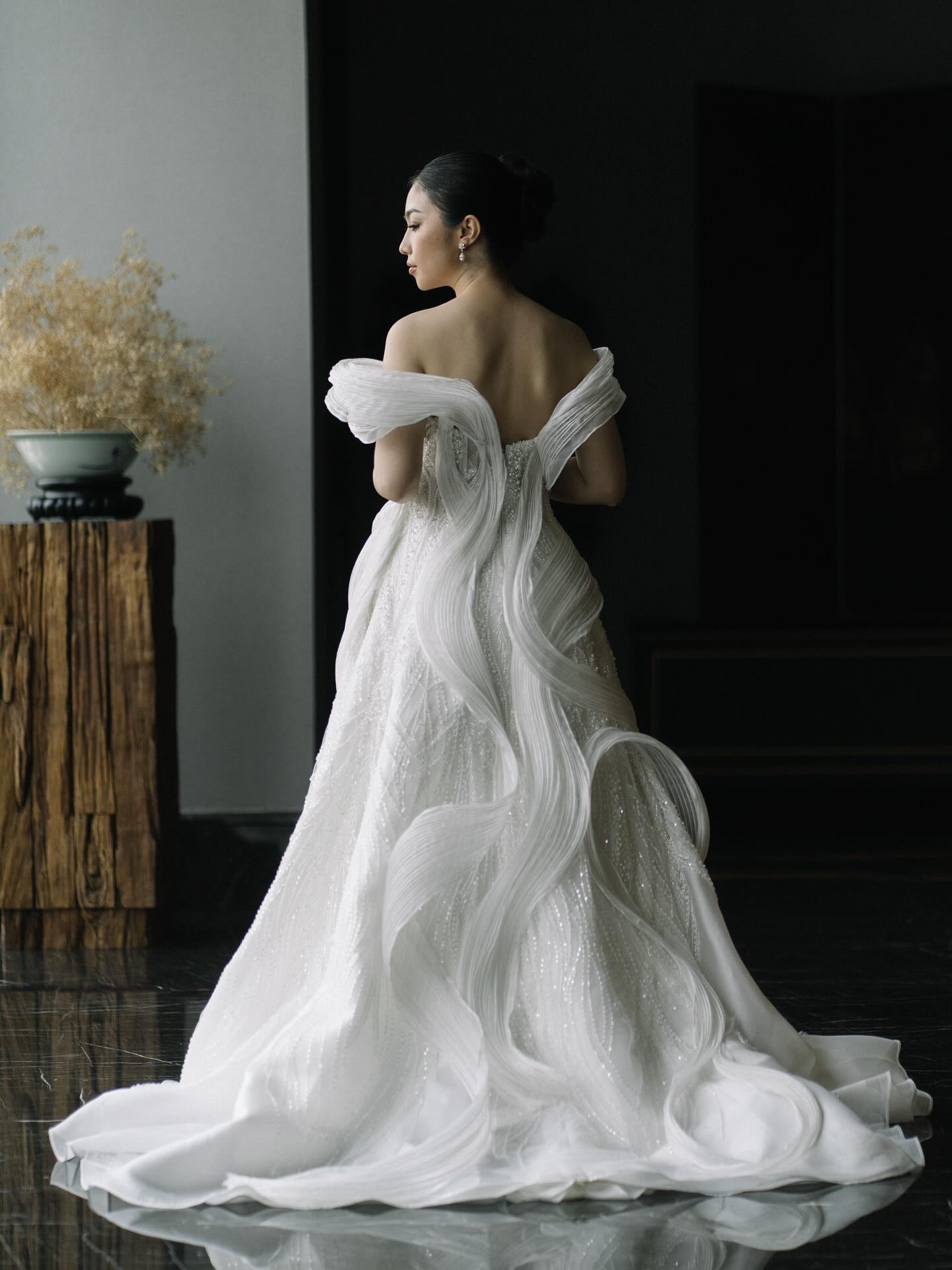 CELRA sculptural white wedding gown with draped train, seen from behind