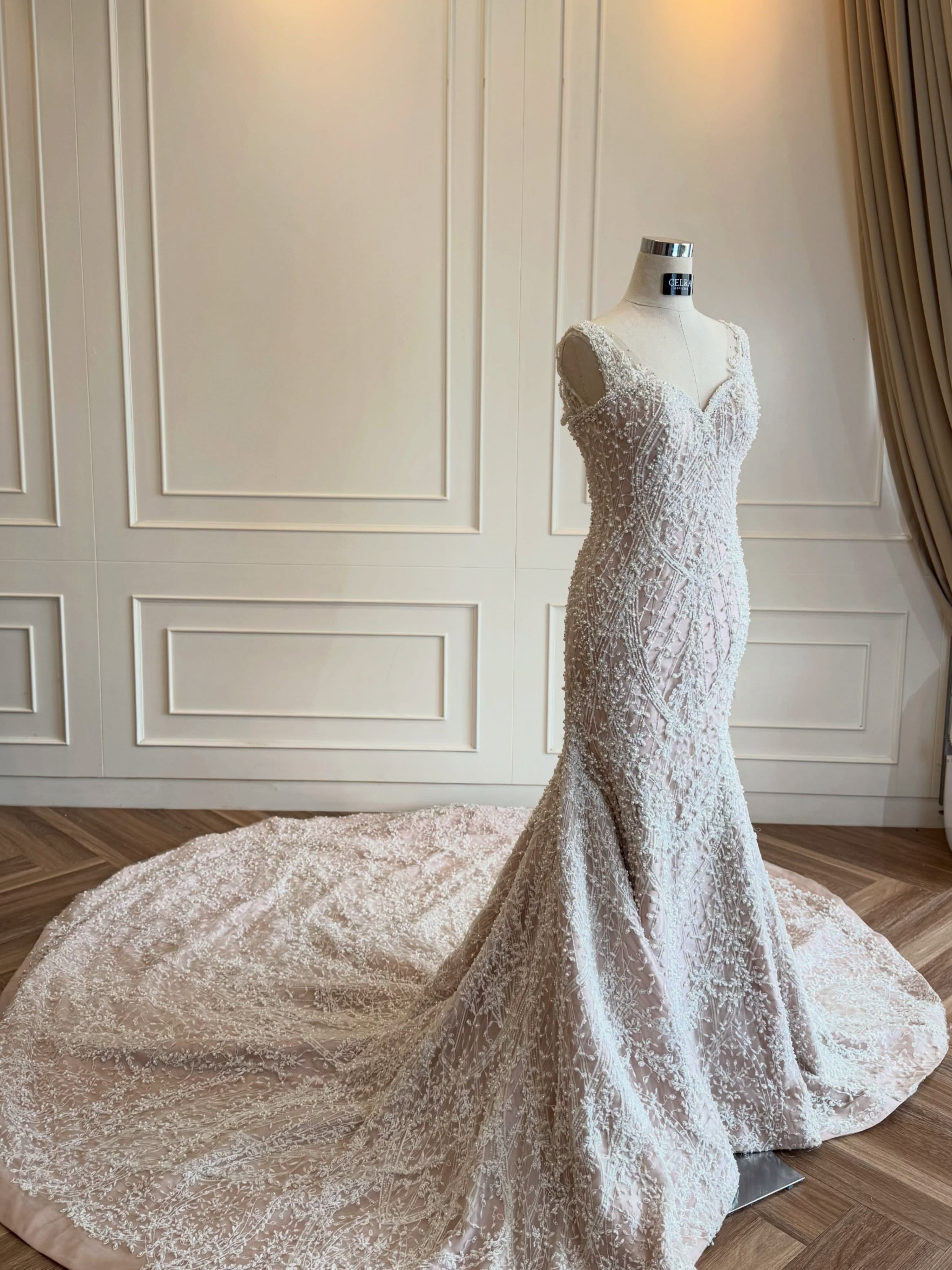 Beaded lace mermaid wedding gown on a mannequin in the atelier by CELRA